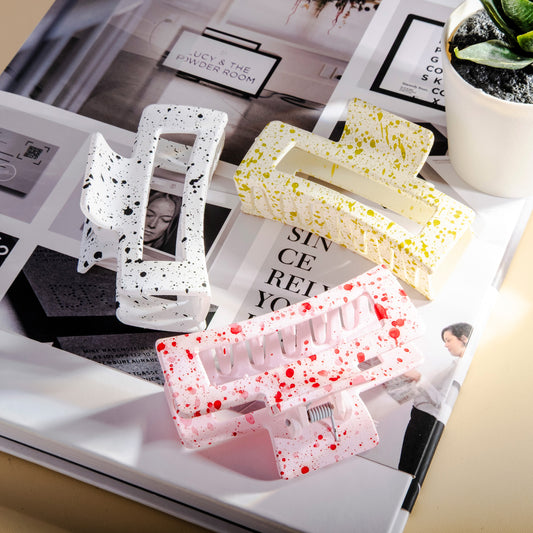 Three decorative hair clips on a magazine with a blurred indoor background